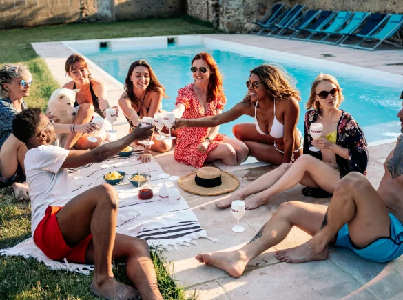 Groupe de jeunes dans une villa piscine, s’amusant sous le soleil avec une ambiance festive